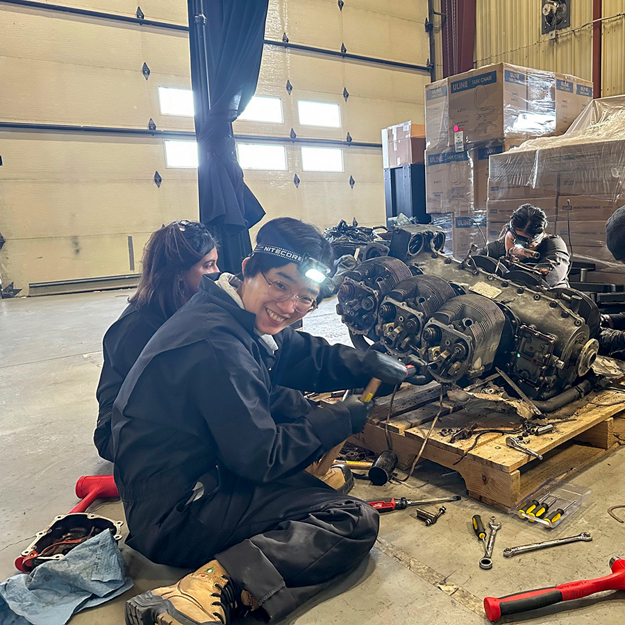 Happy student working on an engine